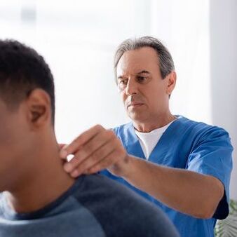 Liječnik provodi dijagnostički pregled bolesnika s bolovima u vratu